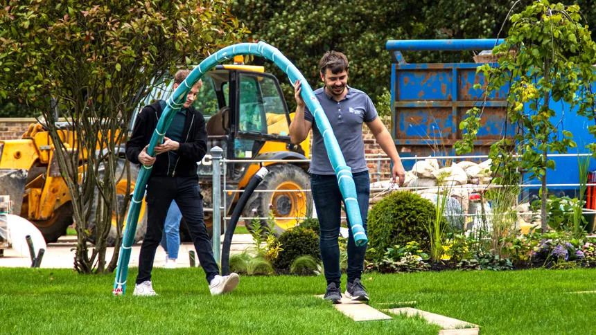 Matt & Kieran carrying one of the electric curtain tracks into the building