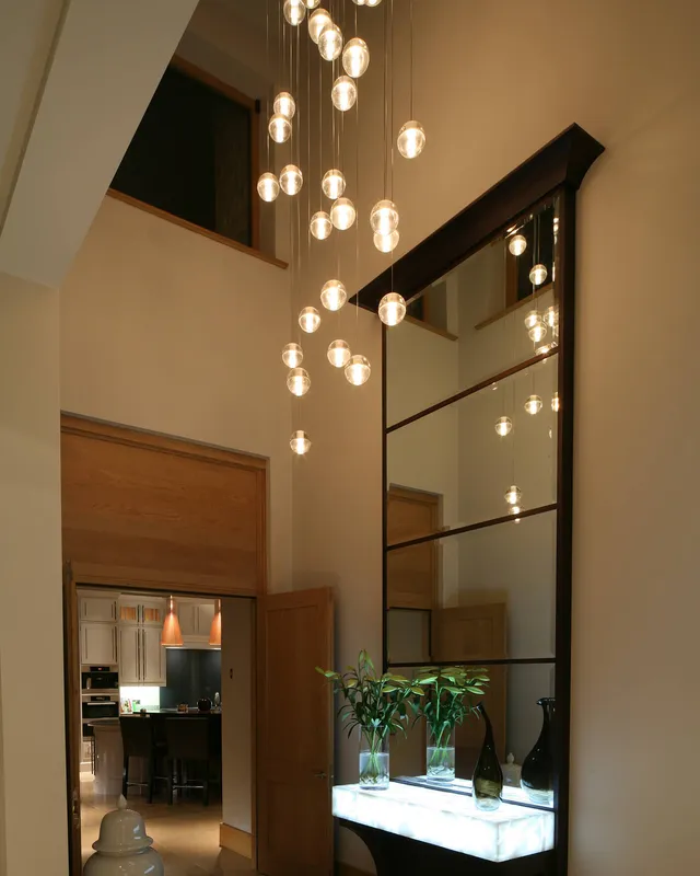 Custom Bocci pendant in a stairwell with a lit onyx table