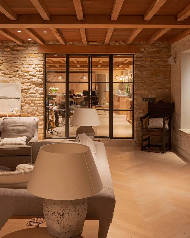 Dramatic evening lighting in the living room with the busy family kitchen dining room beyond