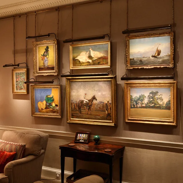 A fine art collection on a fabric wall lit with a bespoke ArtView picture light array from a customised powered hanging rail.