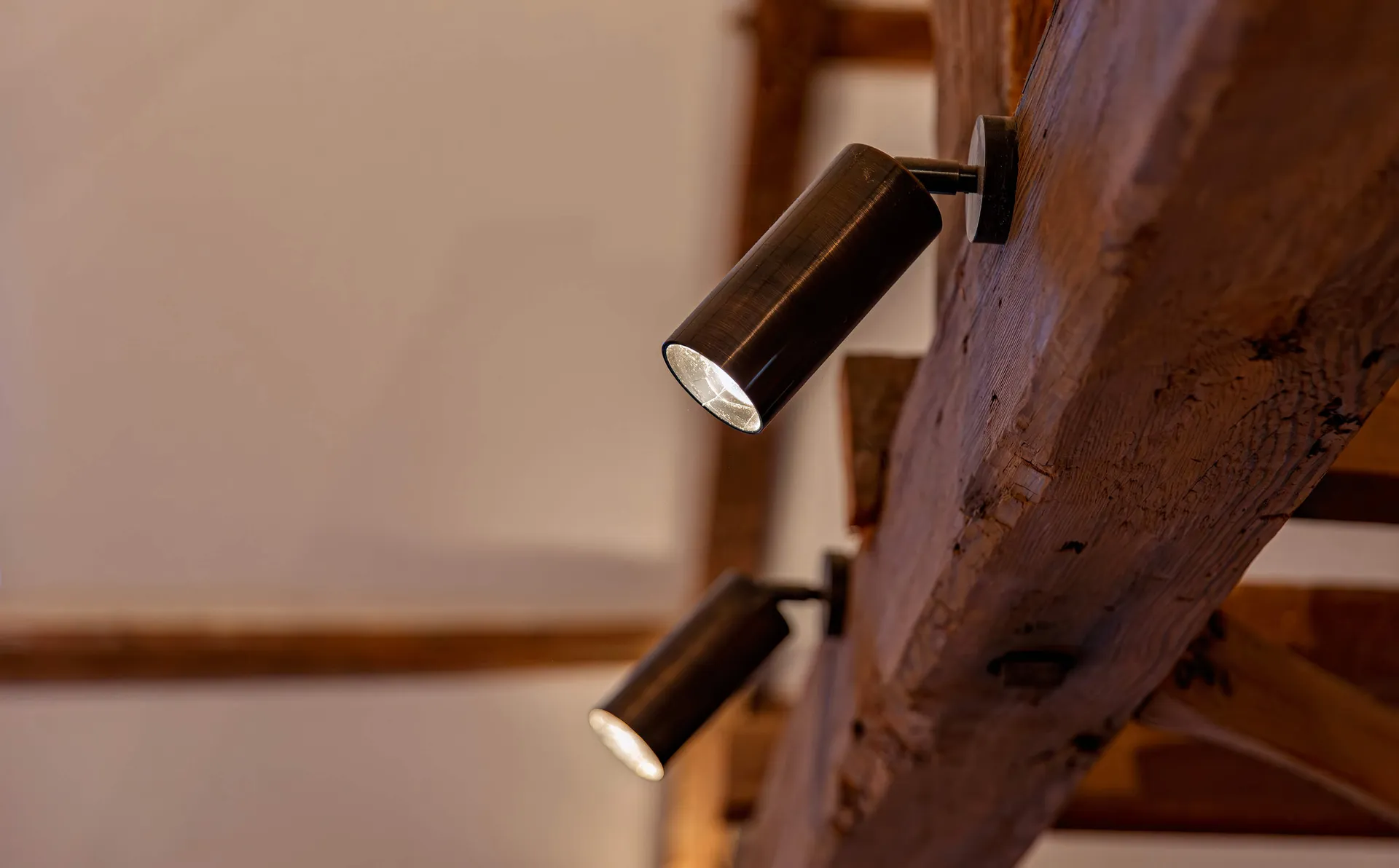 Bronze surface spotlights mounted on a wooden beam