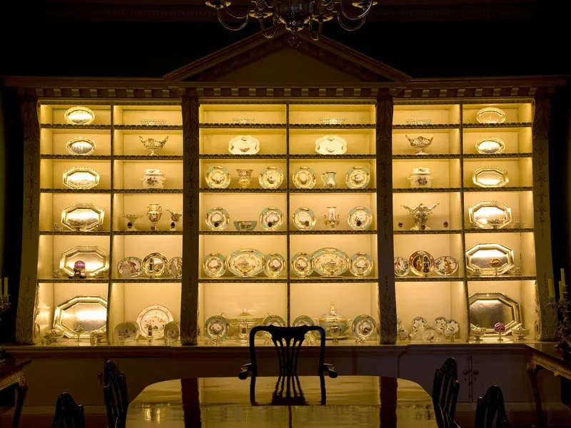 A splendid cabinet of silver and percelain in a dining room in a stately home