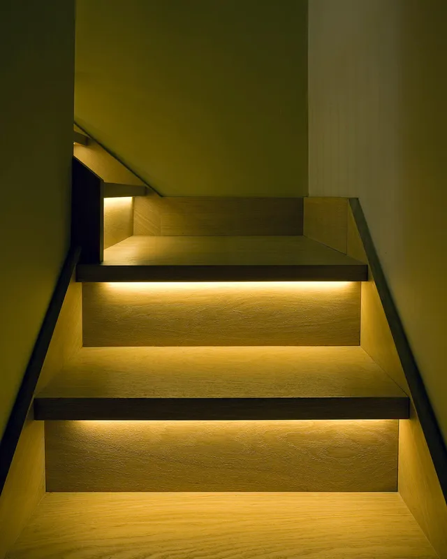 Custom linear LED treadlighting built into a wooden staircase