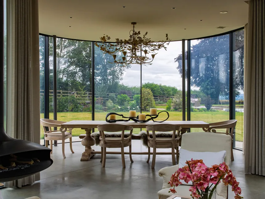 Lutron electric curtain tracks in a striking moden circular glazed dining room