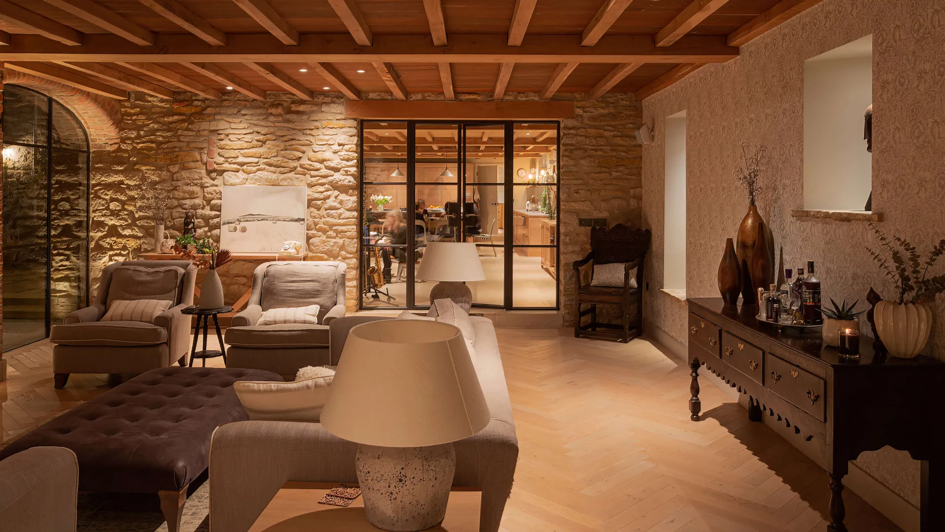 Dramatic evening lighting in the living room with the busy family kitchen dining room beyond