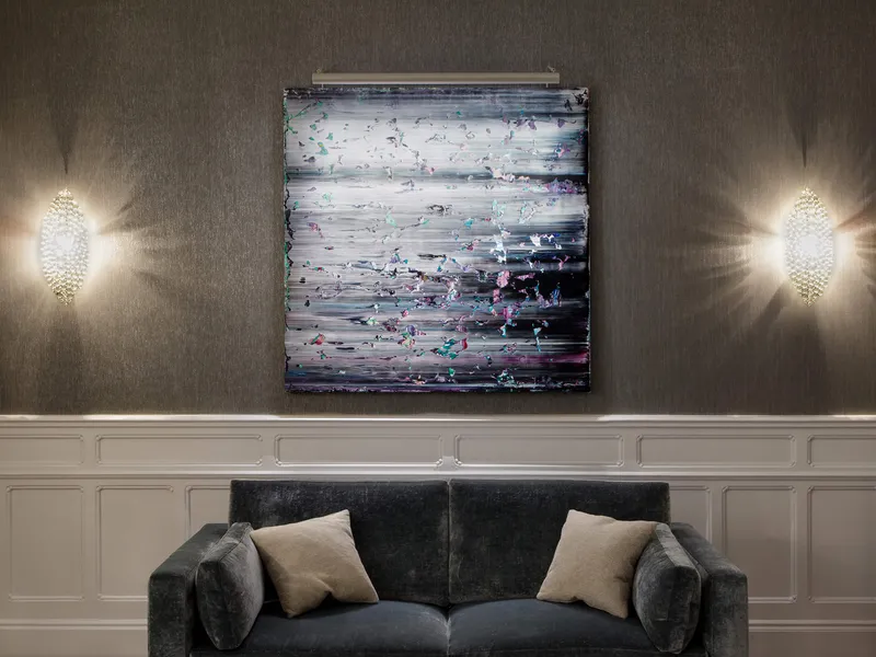 A modern abstract canvas lit with a silvery blue ArtView LED picture light