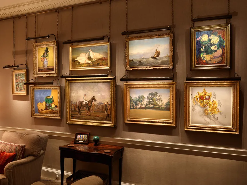 A fine art collection on a fabric wall lit with a bespoke ArtView picture light array from a customised powered hanging rail.