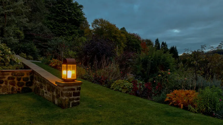 A lantern lights the path in a Yorkshire country garden