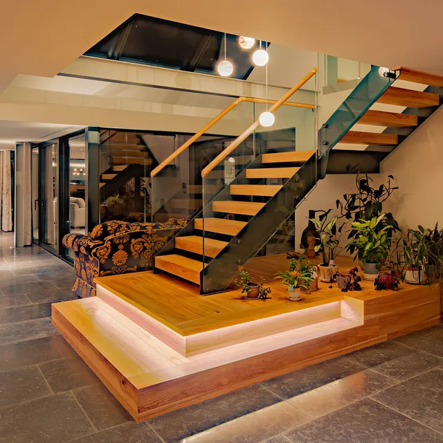 Underlit staircase with a drop chandelier in a modern new-build Lakeland house