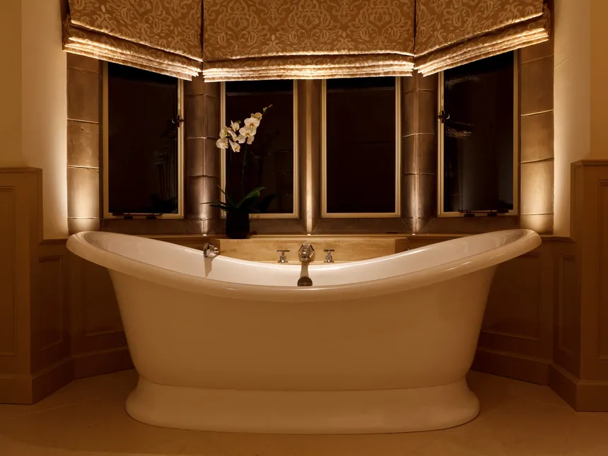 A rool top bath in an Arts & Crafts bathroom subtly lit with downlights and cill recessed accent lights