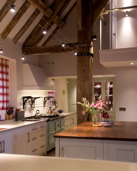 A bespoke track lighting sysetm in a kitchen in a Hamsphire barn with very high ceilings