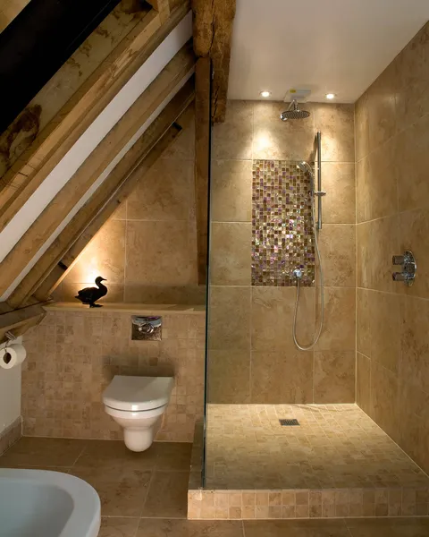 A shower in the eaves of an old barn with downlighting and small LED accent lights