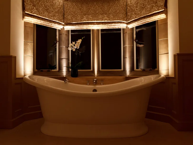 A roll top bath in an Arts & Crafts bathroom subtly lit with cill recessed accent lights only