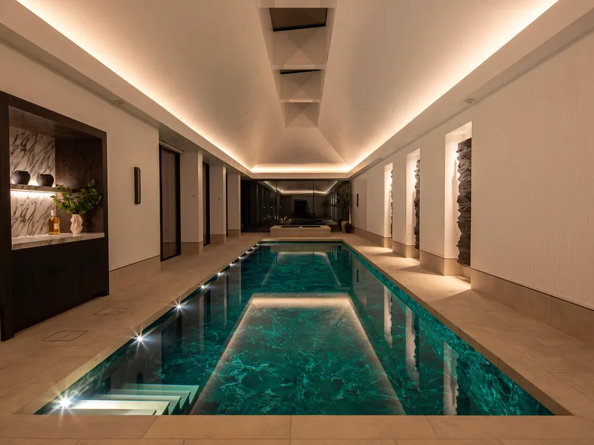 linear lighting framing the vaulted ceiling of a beautiful swimming pool.