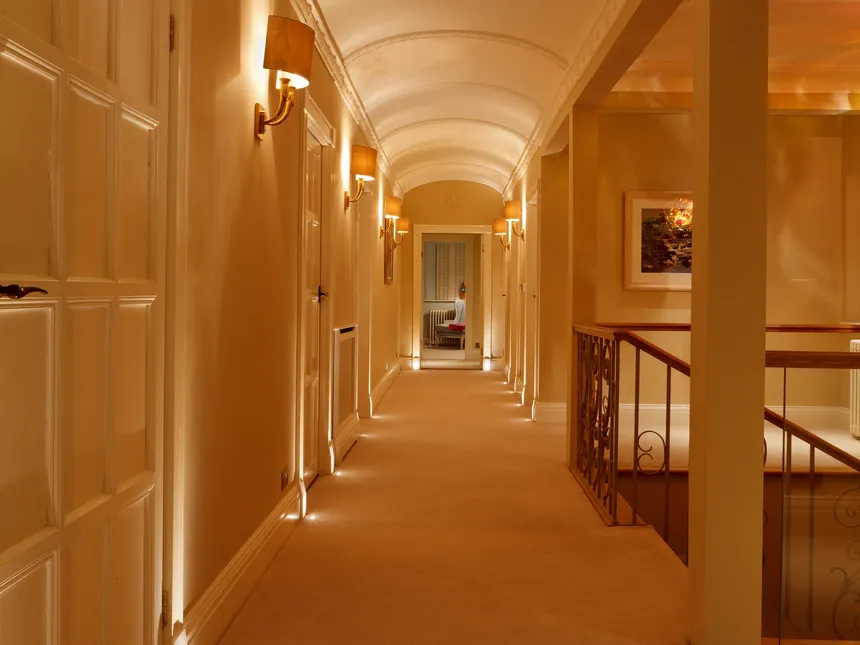 Layered lighting in a corridor in an Arts & Crafts house
