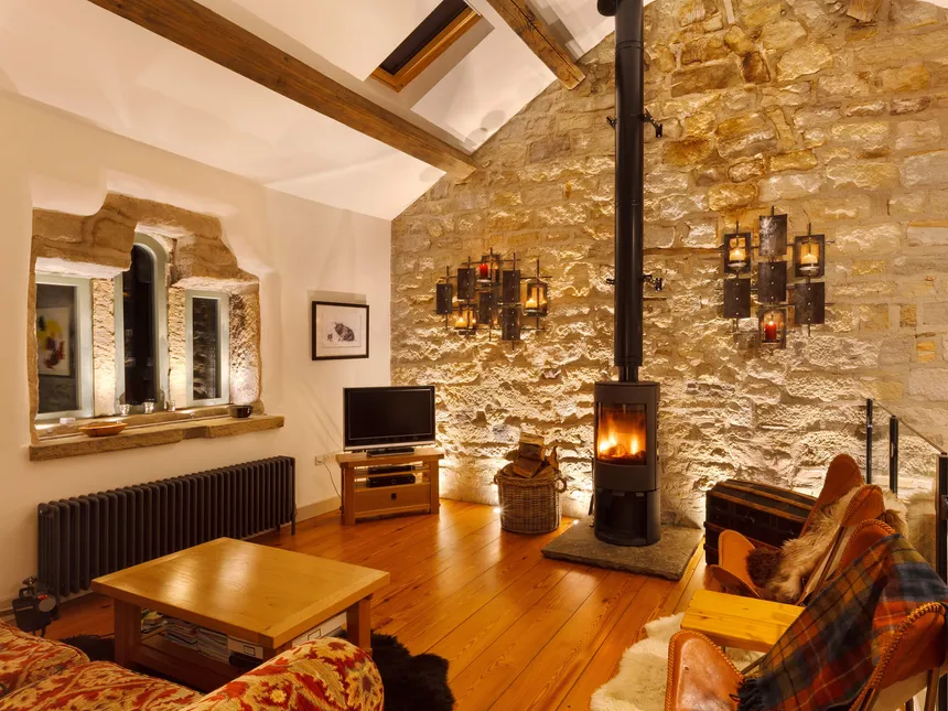 A stone barn conversion with uplit exposed stone wall and window features