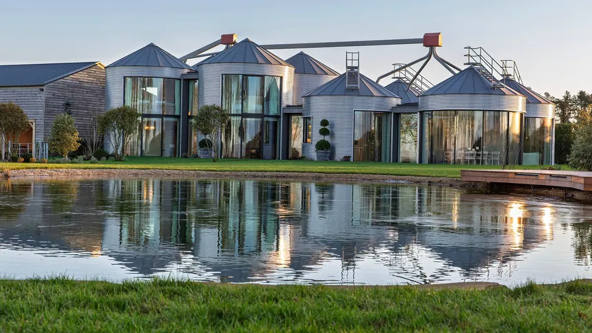 A luxury house converted from grain silos in the late afternoon across a frozen lake