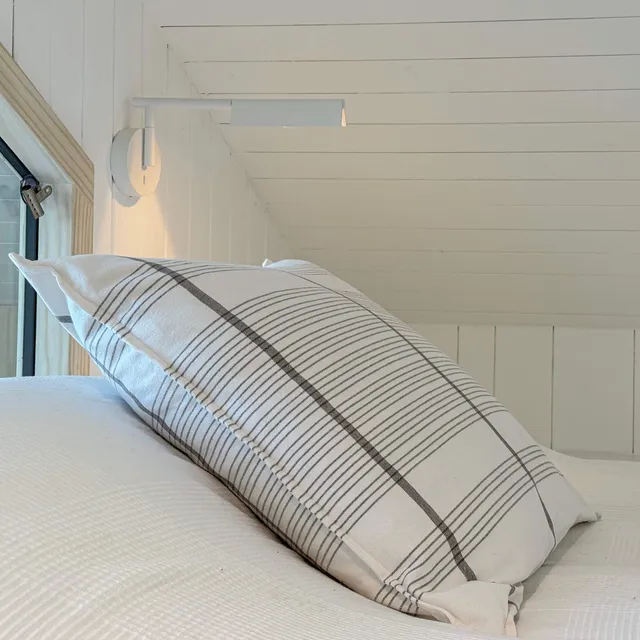 Simple glare-free surface mounted reading lights at the end of a Scandi style bed