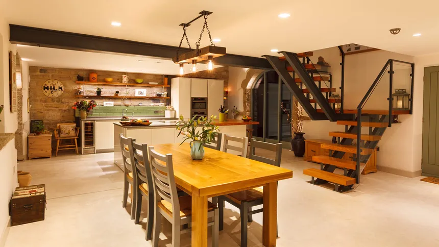Modern kitchen with open staircase and wooden pendant over the dining table