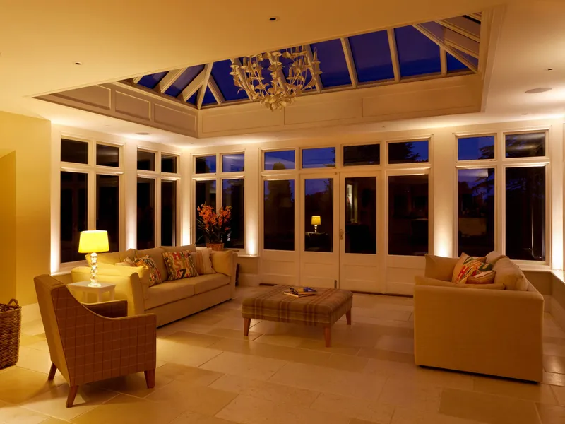 An orangery at "Blue hour" with subtle LED accent uplighting and table lamps