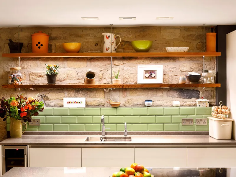 Task lighting over a kitchen island with LED linear lighting in the shelves