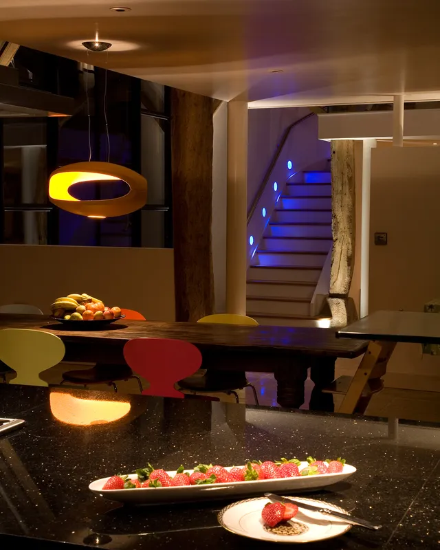 Fun and colour; the decorative lamp over the table matches the "Ant" dining chairs and blue LED accent lighting leads your eyes up the staircase