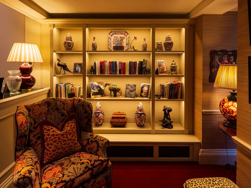 A snug reading area with cosy table lamps and lit bookcases