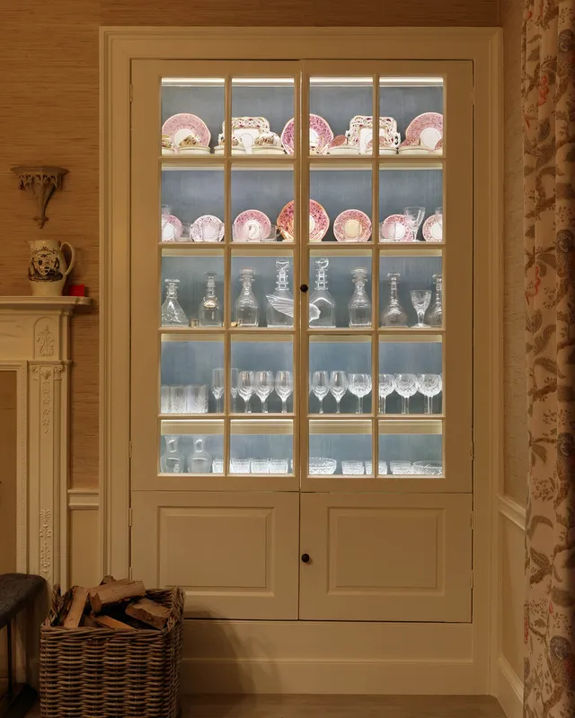 A brightly lit cabinet with fine china and cabinet in a Georgian country house