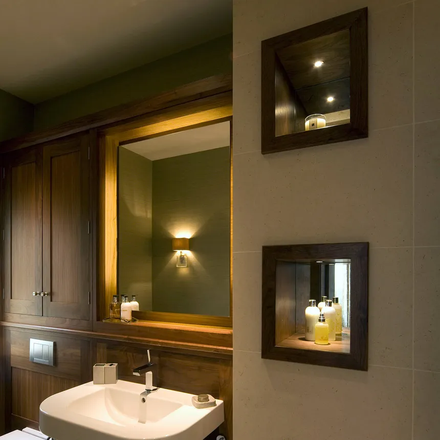 A backlit mirror and mirrored niches lit with miniature LED accent lights 