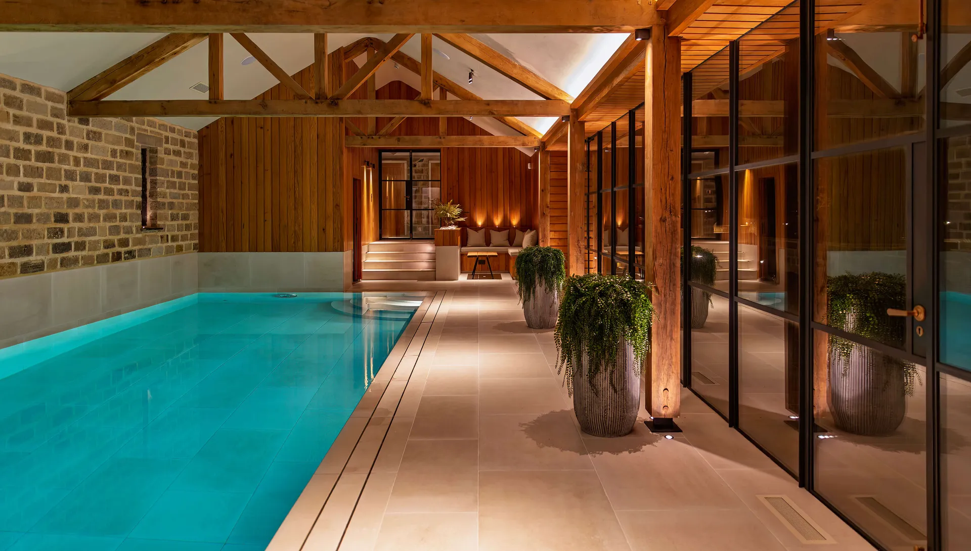 Indoor swimming pool with seating area at the end