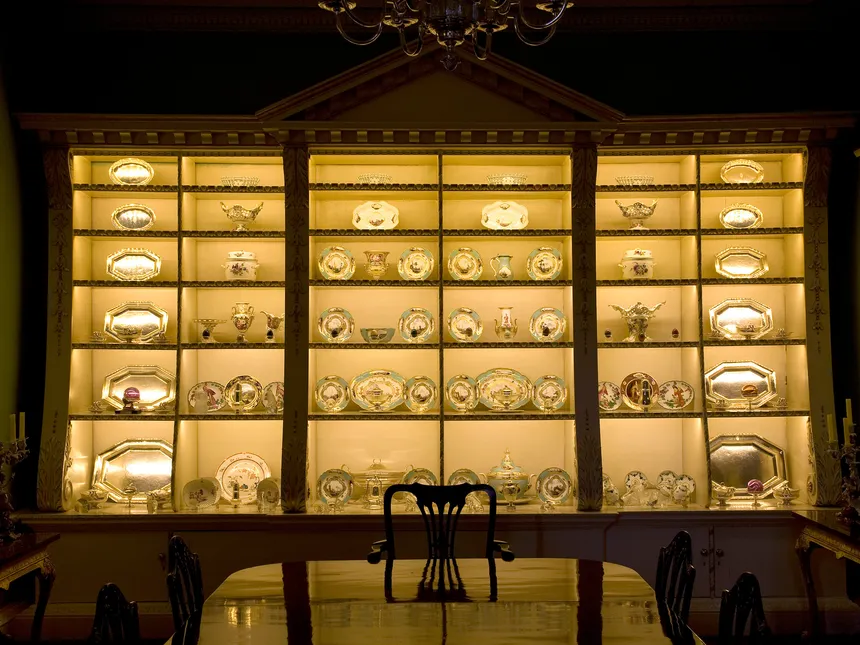 An elegant dresser full of silver and porcelain lit by concealed LED fittings