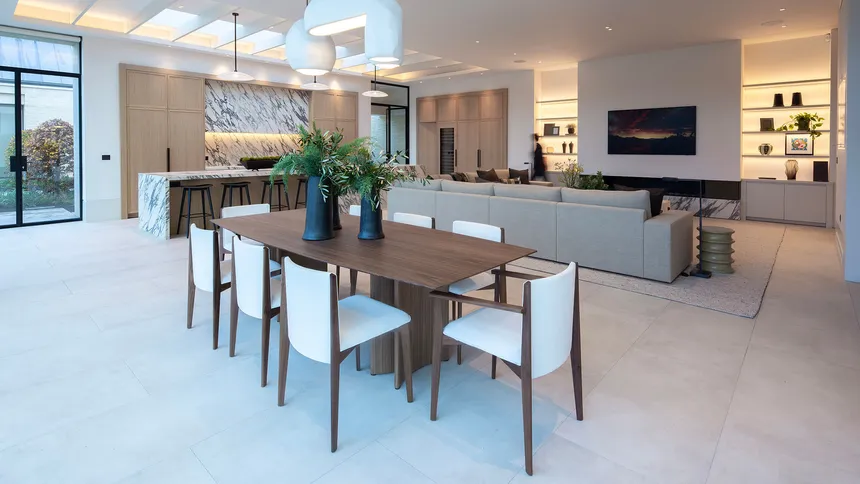 Late afternoon shot of a large open plan kitchen, dining, living space with the lights just starting to show.