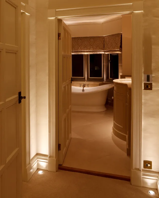 An Arts & Crafts bathroom with accent uplighting in the cill and round the door