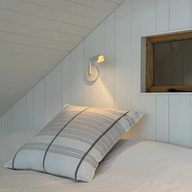 Simple glare-free surface mounted reading lights at the end of a Scandi style bed