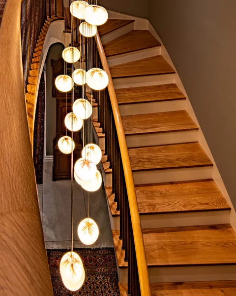 A decoirative pendant illuminating an elegant oak and steel staircase