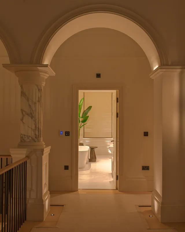 A Victorain landing in the early evening with a brightly lit bathoom leading off