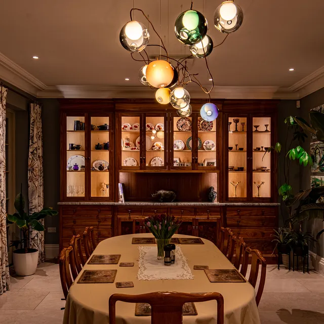 Multi coloured glass ball pendant over traditional dining room table