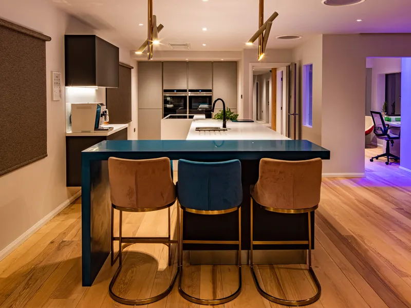 A sleek, modern kitchen with feature lighting over the breakfast bar