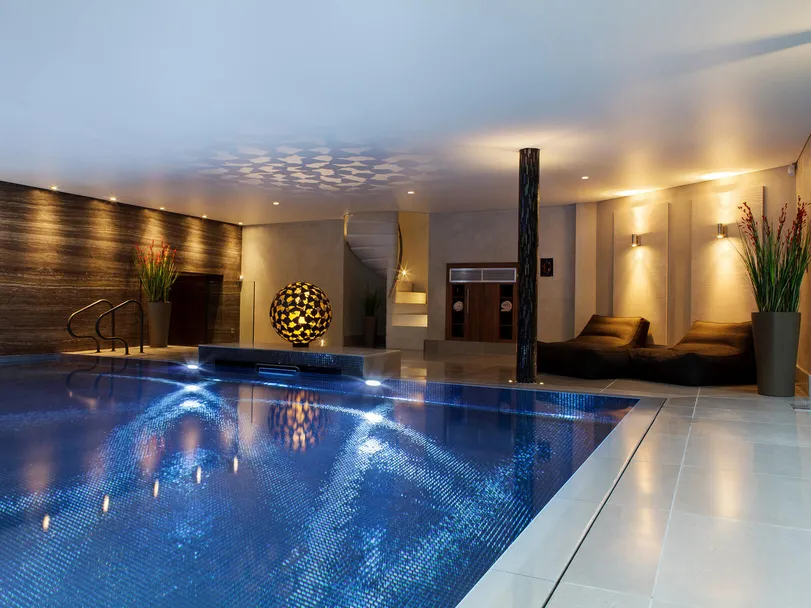 A luxurious swimming pool in a private spa with the pool lighting on