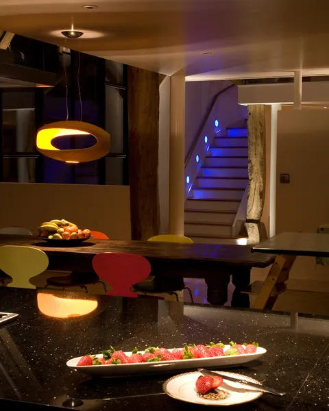 Fun and colour; the decorative lamp over the table matches the "Ant" dining chairs and blue LED accent lighting leads your eyes up the staircase