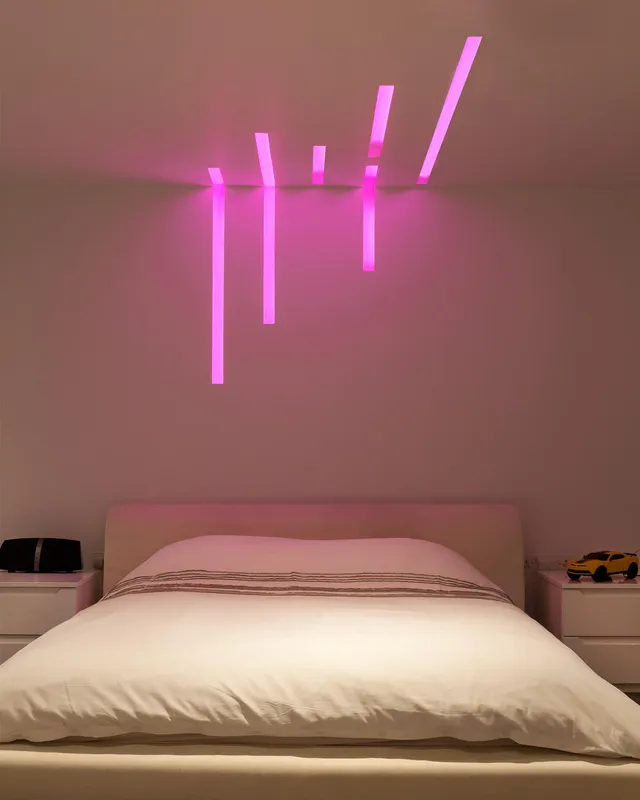 Colour-changing LED linear fittings in Sedap profiles in a teenager's bedroom 