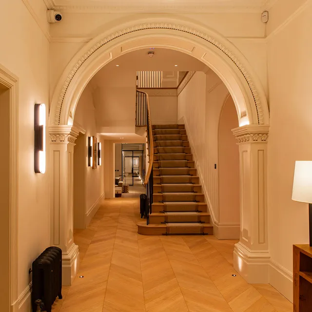 An uplit arched hallway in a Victorian villa with wall lighting