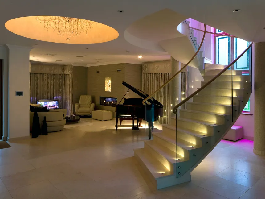 Staircase lighting and a feature chandelier in a light well in a North London family home