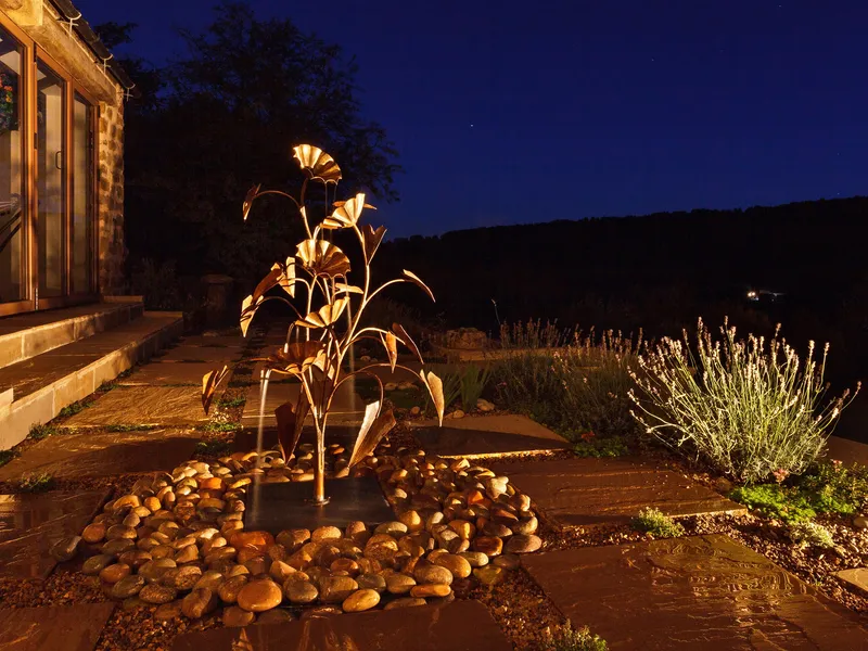 A copper water feature lit by a concealed small LED accent light