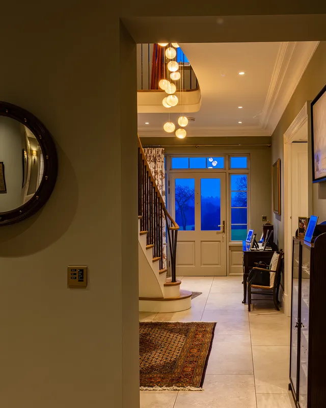 Hallway lit with downlights and glass drop pendant