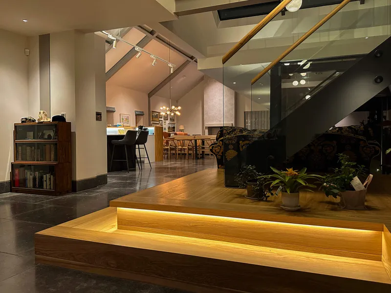 Under-tread linear LED lighting on a timber, glass and steel staircase