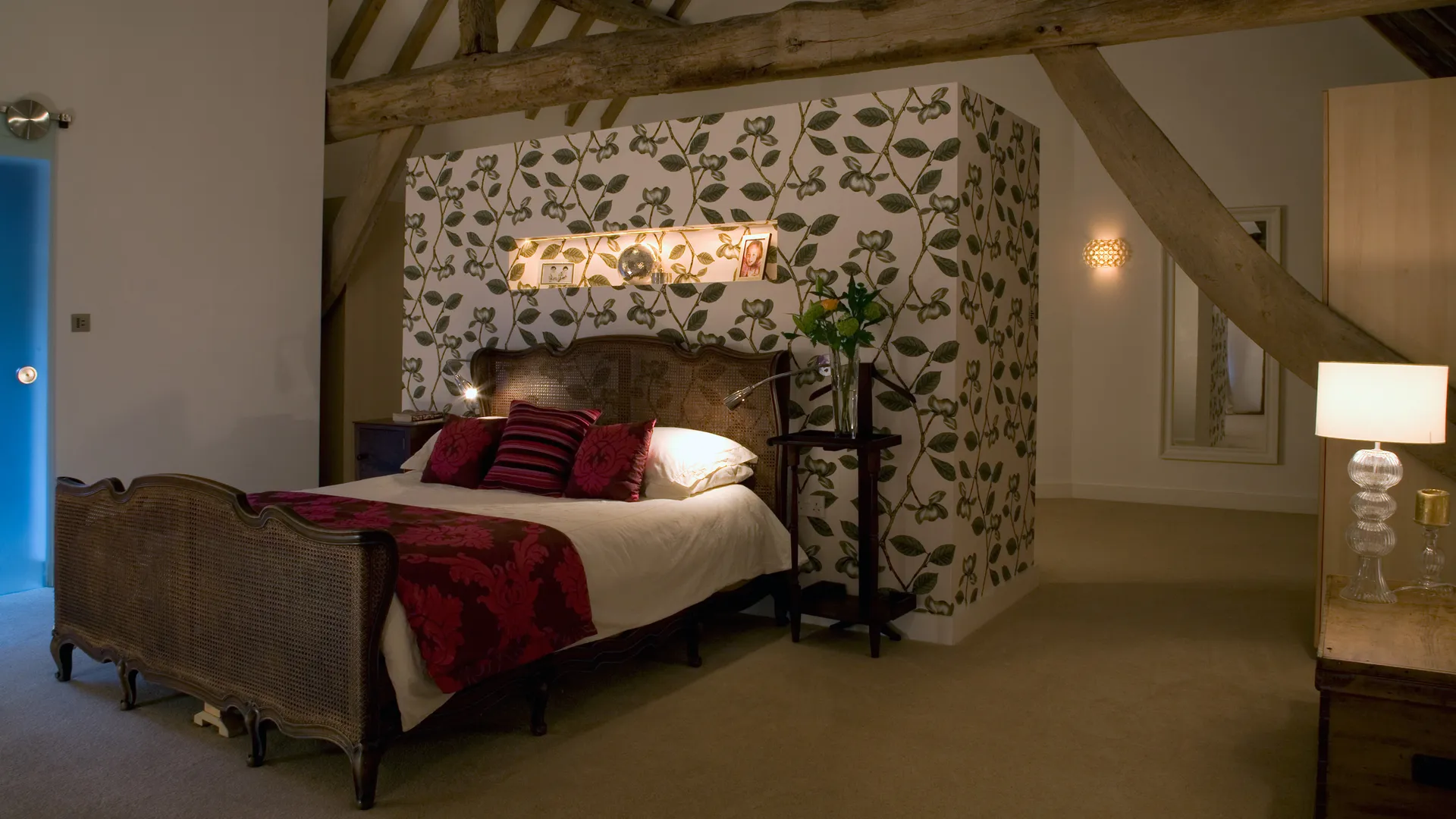  A lit niche, elegant decorative fittings and fexible reading lights in a barn conversion bedroom