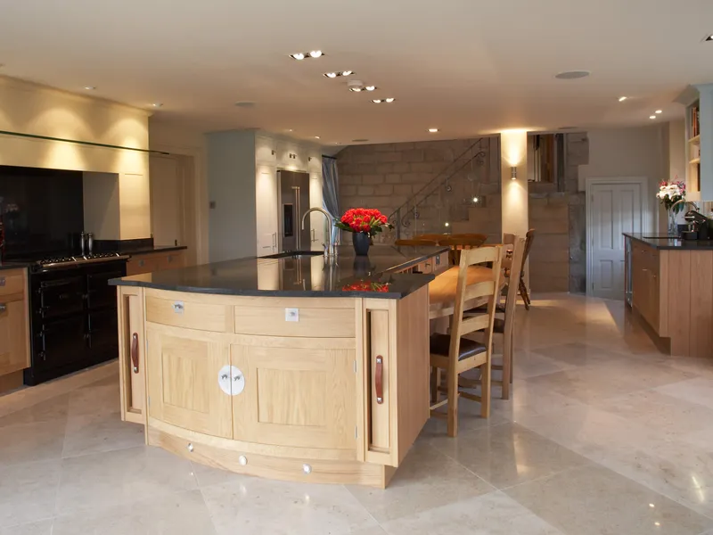 A large Smallbone kitchen with range and large central island lit with hihg-output downlights