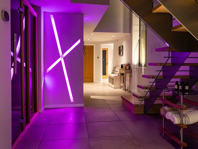 Colour changing recessed linear LED lighting in a new-build house, magenta