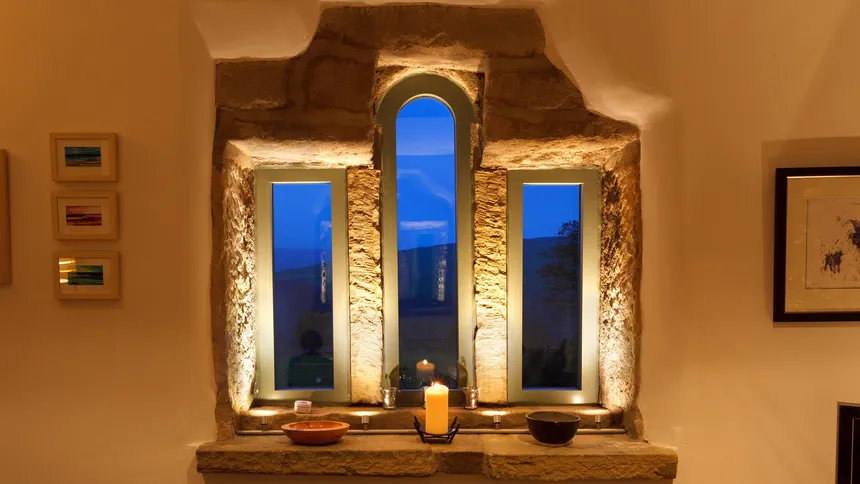 Beautiful pold stone barn window lit with miniature accent lights on custom mounting rail